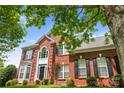 A striking two-story brick home with black shutters, a well-kept lawn, and mature landscaping at 6803 Augustine Way, Charlotte, NC 28270