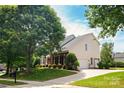 Well-maintained home with lush lawn, mature trees, brick accents and attached garage on a sunny day at 6803 Augustine Way, Charlotte, NC 28270