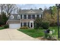 Charming two-story brick home with a well-manicured lawn, two-car garage, and classic black shutters at 7700 Antique Cir, Waxhaw, NC 28173
