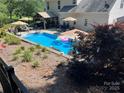 Aerial view of the backyard pool with cabana, umbrellas, lounge chairs, and meticulous landscaping at 7700 Antique Cir, Waxhaw, NC 28173