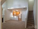 Bright, open living room with fireplace, stairs, and seamless flow to kitchen area at 8838 Wandering Creek Way, Charlotte, NC 28227