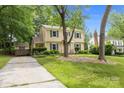 Traditional home with green shutters and a well-maintained lawn, complemented by mature trees and an ample driveway at 906 Wishing Well Ln, Charlotte, NC 28270