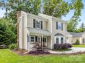 This lovely two-story home features an attached single-car garage, complemented by verdant landscaping and mature trees at 9908 Park Springs Ct, Charlotte, NC 28210