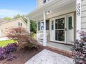 Welcoming front porch with a seating bench and decorative plants leading to the front door at 9908 Park Springs Ct, Charlotte, NC 28210