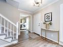 Inviting foyer with wood floors, white staircase, and stylish decor at 113 Foxfield Ln, Matthews, NC 28105