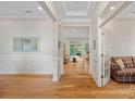 Elegant foyer with hardwood flooring, decorative molding, and a view into the spacious living area at 114 Canoe Pole Ln, Mooresville, NC 28117
