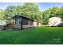 Spacious backyard featuring the home's exterior and a storage shed, surrounded by lush greenery at 121 C And C Ln, Mooresville, NC 28115