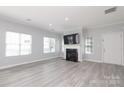 Bright living room with hardwood floors, a fireplace, and large windows offering ample natural light at 12321 Aquitaine St, Charlotte, NC 28277