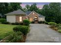 Beautiful single-story brick home with a well-kept lawn and a picturesque dusk backdrop at 172 Hunters Hill Dr, Statesville, NC 28677