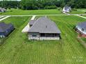 Aerial view of a house with a large yard, gray roof and exterior AC units at 174 Bellingshire Dr, Mt Ulla, NC 28125