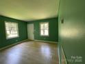 Inviting living room with natural light, featuring new flooring and fresh green paint at 1824 Maribel Ave, Charlotte, NC 28216