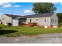 Large, level backyard featuring a wooden deck with a built-in hot tub at 24007 Old Aquadale Rd, Albemarle, NC 28001
