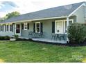 Inviting front porch with table and chairs provides an outdoor seating area at 24007 Old Aquadale Rd, Albemarle, NC 28001