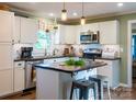 Updated kitchen features stainless appliances, pendant lighting, and a butcher block island at 24007 Old Aquadale Rd, Albemarle, NC 28001