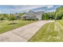 Lovely home with an extended driveway leading to a side-entry garage and mature landscaping at 314 Candella Dr, Matthews, NC 28104