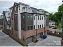 A townhome features a brick and siding exterior with garage and private rooftop deck in a modern neighborhood at 4121 Selwyn Walk Ct, Charlotte, NC 28209