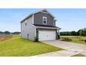 Two-story home showcasing gray siding, stone accents, and an attached two-car garage with an expansive lawn at 415 Luna Ln, Shelby, NC 28152