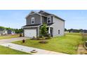 Two-story home with gray siding, a stone-accented garage, and well-kept landscaping on a green lawn at 415 Luna Ln, Shelby, NC 28152