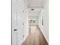 Bright hallway with wood floors and white trim, leading to a staircase and windows with a view at 415 Luna Ln, Shelby, NC 28152