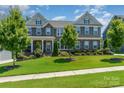 Beautiful two-story home featuring a lush green lawn, stone accents, and a covered front porch at 4386 Oldstone Dr, Harrisburg, NC 28075
