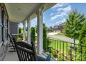 Relaxing front porch with black rocking chairs and a view of the well-manicured neighborhood at 4386 Oldstone Dr, Harrisburg, NC 28075