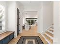 Bright foyer with hardwood floors, staircase, and entryway into dining and living areas at 6242 Creola Rd, Charlotte, NC 28270