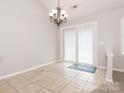 Bright dining area with tile flooring, a chandelier, and sliding door access to the exterior at 703 Bradberry Ln, Indian Trail, NC 28079