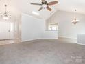 Open-concept living space featuring neutral paint, carpeted floors, and modern lighting at 703 Bradberry Ln, Indian Trail, NC 28079