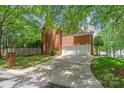 Back of brick home featuring a three car garage and wide driveway at 7301 Leharne Dr, Charlotte, NC 28270