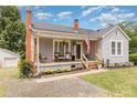 Charming single-story home with a cozy front porch, swing and well-manicured landscaping at 810 Maplewood Ave, Kannapolis, NC 28081