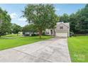 Charming two-story home with light brown siding, red shutters, well-manicured lawn, and long paved driveway at 8618 Sam Dee Rd, Charlotte, NC 28215