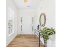 Bright entryway with new laminate flooring, a plant, a large mirror and a white front door at 9030 Gander Dr, Charlotte, NC 28277