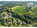 Aerial view showcasing the neighborhood's lush greenery and proximity to a large green sports field at 9038 Sandpiper Dr, Charlotte, NC 28277