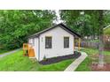 Side view of a charming home with fresh exterior paint, black trim, and a sidewalk at 922 Maurice St, Monroe, NC 28112