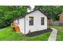 Side view of a charming home with fresh exterior paint, black trim, and a wooden deck at 922 Maurice St, Monroe, NC 28112