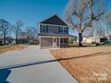 Charming two-story home with a gray exterior, well-manicured lawn, and a concrete driveway on a sunny day at 1017 W C St, Kannapolis, NC 28081