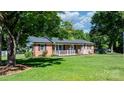 Classic brick home featuring a welcoming porch and a lush green lawn at 135 Burton Hills Cir, Gastonia, NC 28054