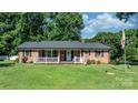 Traditional brick home with a cozy front porch and well-maintained lawn at 135 Burton Hills Cir, Gastonia, NC 28054