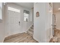 Bright foyer with wood-look floors, staircase, coat closet, and front door with sidelight at 150 Bezelle Ave, York, SC 29745
