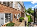 Townhome exterior with brick accents, gated entry, and manicured landscaping at 15209 Loire Valley St, Charlotte, NC 28277