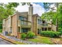 Multi-level condo with brick and siding exterior, surrounded by lush trees and landscaping at 1606 Sharon W Rd # 40, Charlotte, NC 28210