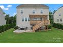 Spacious backyard featuring a wooden deck with pergola, a stone patio with fire pit, and lush greenery perfect for outdoor living at 17231 Rider Wood Ln, Charlotte, NC 28278