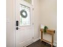 Bright and welcoming foyer featuring a white door with a decorative glass window and wood flooring at 1825 Evergreen Dr, Charlotte, NC 28208