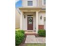 Inviting front entrance with a decorative wreath, brick accents, and a covered porch at 1825 Evergreen Dr, Charlotte, NC 28208