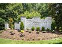 Welcome to Sutton Place! Elegant white brick community sign surrounded by lush landscaping and greenery at 1846 Sam Smith Rd, Fort Mill, SC 29708