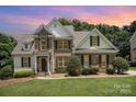 Charming brick and siding home with a well-manicured lawn and a picturesque sunset sky. A beautiful two-story Gathering home at 1846 Sam Smith Rd, Fort Mill, SC 29708