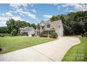 Spacious home with a long driveway, lush green lawn, and mature trees; perfect for Gathering living at 1846 Sam Smith Rd, Fort Mill, SC 29708