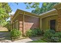 Brick home featuring a covered front entrance and attached garage, with mature landscaping at 212 Foxfield Ln, Matthews, NC 28105