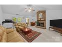 Inviting living room features a brick fireplace, neutral carpet and opens to dining area at 212 Foxfield Ln, Matthews, NC 28105