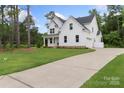 Striking two-story home with a long driveway and luscious green lawn surrounded by mature trees at 3222 Player Ct, Salisbury, NC 28144